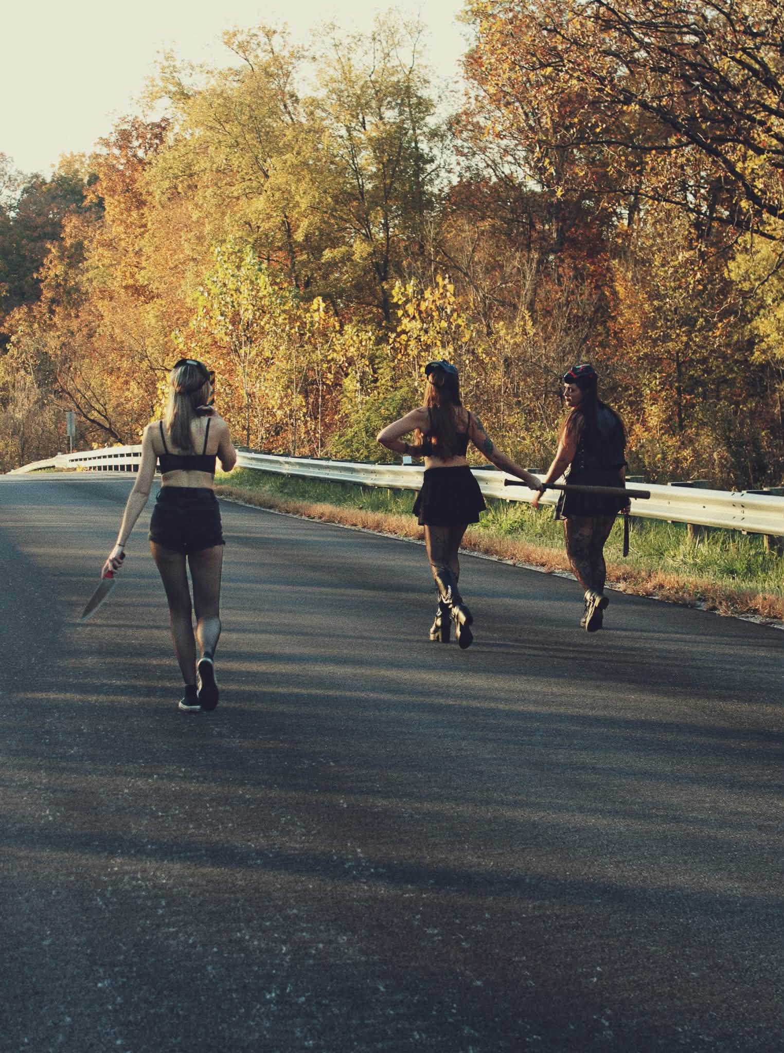 Friends walking along an autumn road in seasonal costumes