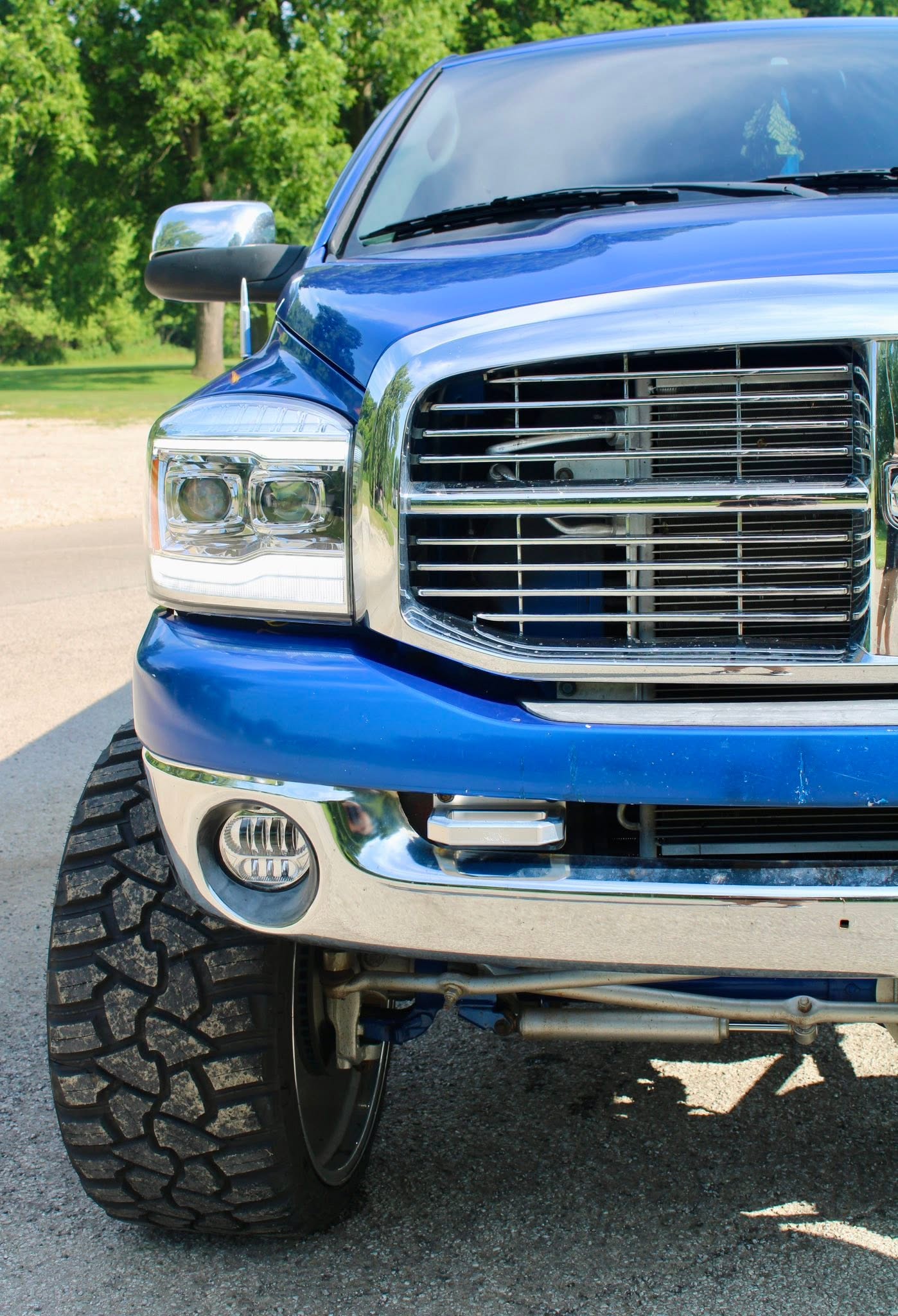 A blue pickup truck photographed beside the water